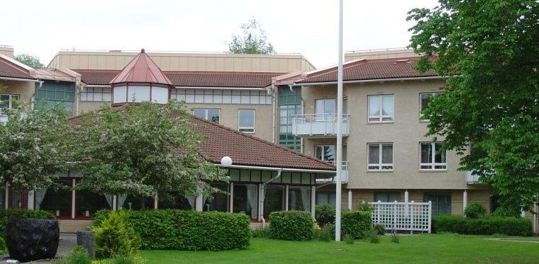 Luddö från framsidan: en stor paviljong och flera byggnader som har tre våningsplan.