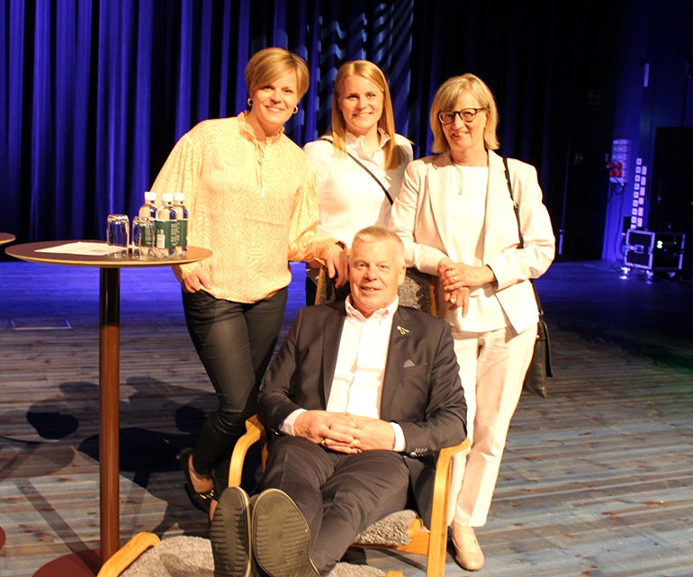 Bild som visar Hans-Göran Johansson som sitter i en stol. Bakom honom står döttrarna Caroline och Amanda och hustrun Ros-Marie.