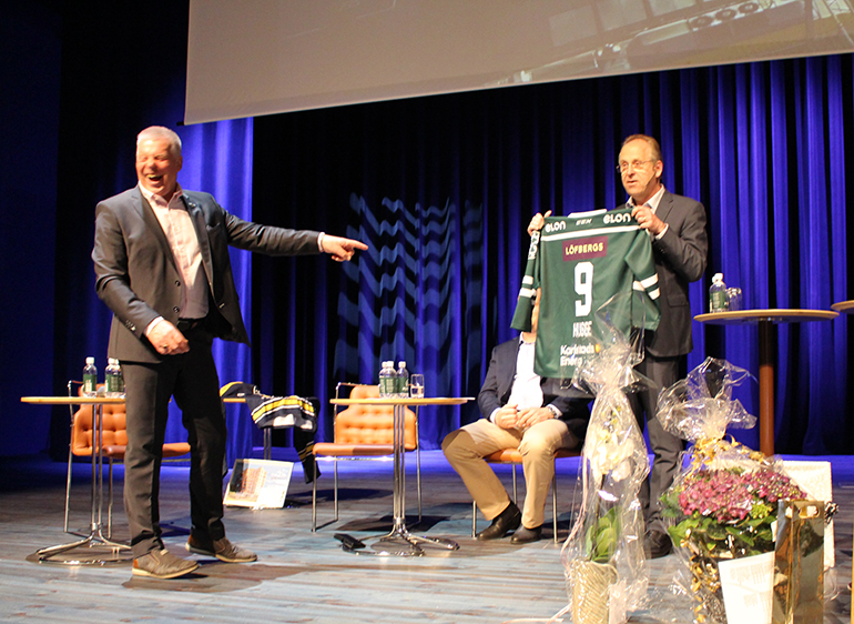 Bild som visar Ulf Svensson som lämnar över en matchtröja för Färjestad till Hans-Göran.
