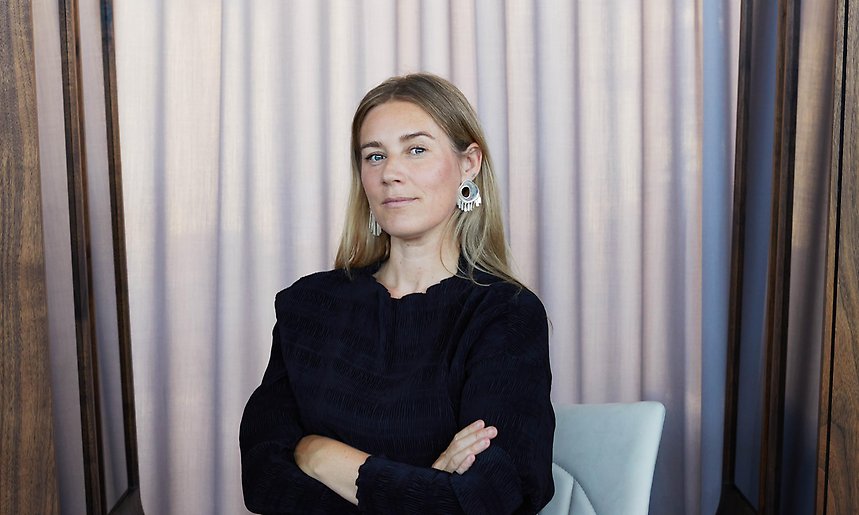 Maria Bruun sitter svartklädd i en stol med armarna i kors.