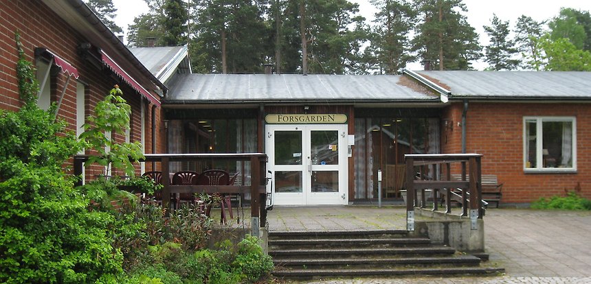 Entrén till Forsgården: röda tegelbyggnader i ett plan.