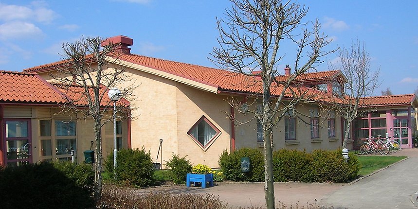 Entrén till Lindgården: sammansatta, gula tegelbyggnader i ett plan.