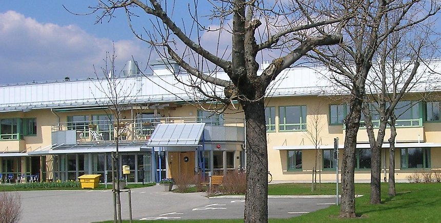 Entrén till Linneberg: sammansatta gula byggnader i två plan.